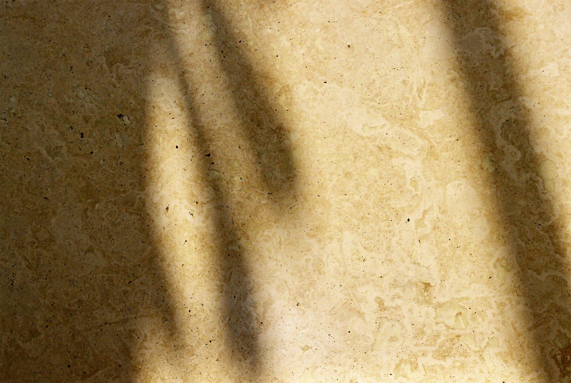 Luz de ventana sobre una pared de piedra clara